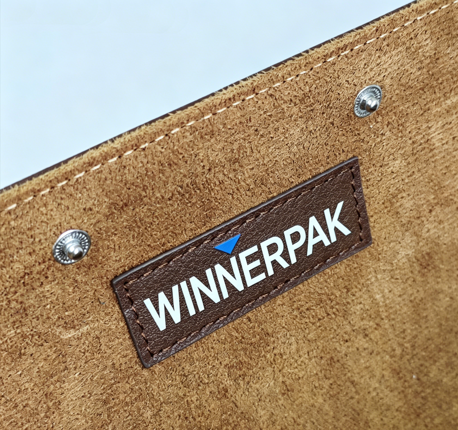 Custom Winnerpak logo patch inside a brown leather 4 watch roll case with tan suede lining and snap buttons.